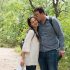 Young husband kissing his beautiful wife while theiy are walking in the woods